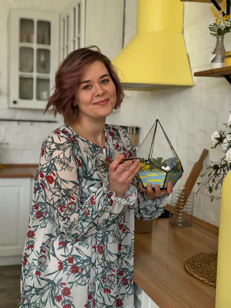 Dasha, founder of Floralab, holding a glass terrarium