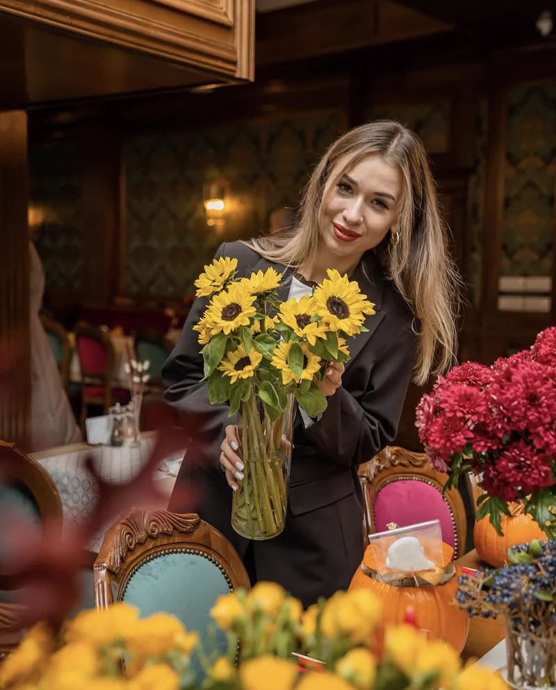 Vlada, founder of Bloom Event Studio, with a bouquet of sunflowers