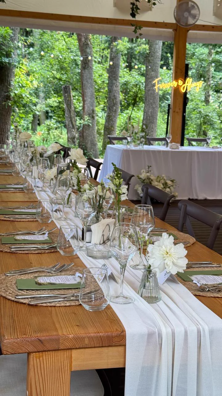 Wedding table with white flowers in a forest pavilion