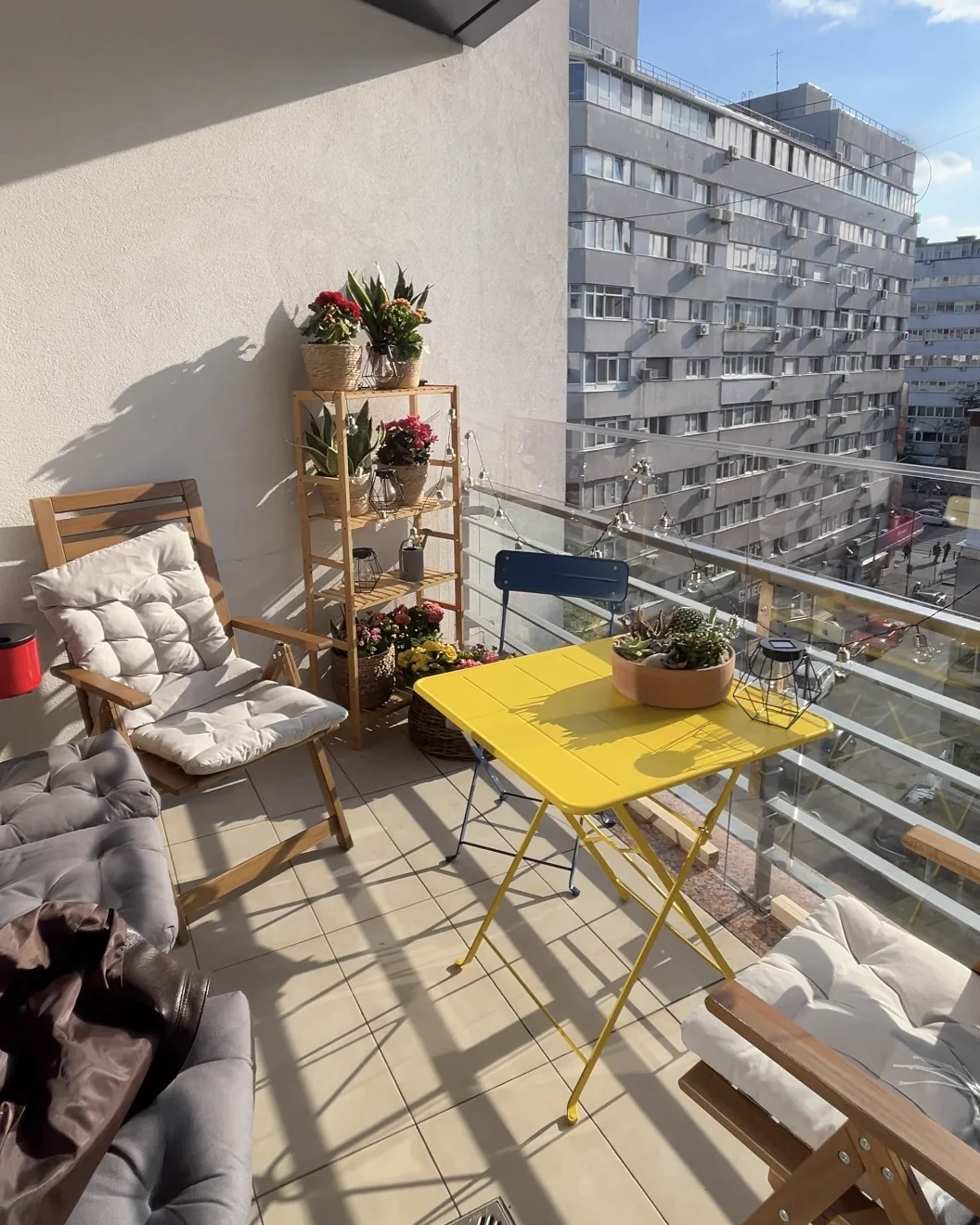 Styled balcony with plant shelf and bistro table